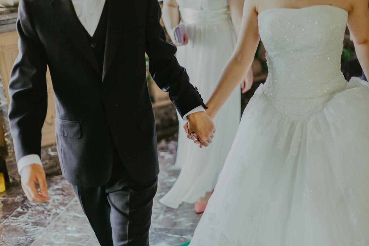 Couple holding hands on their wedding day as they exit their wedding Pexels - Jeremy Wong