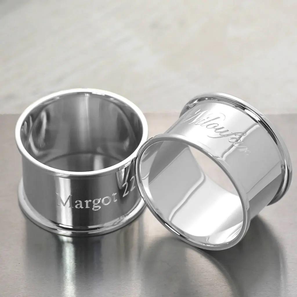 A pair of silver napkin rings personalised with names and date.