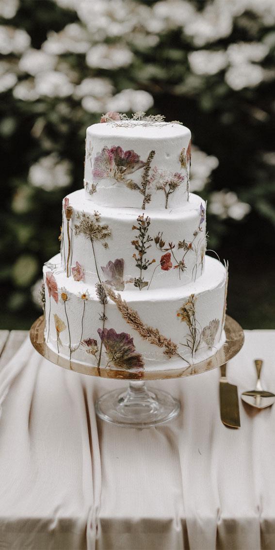 Three tiered white fondant rustic wedding cake with dried flowers