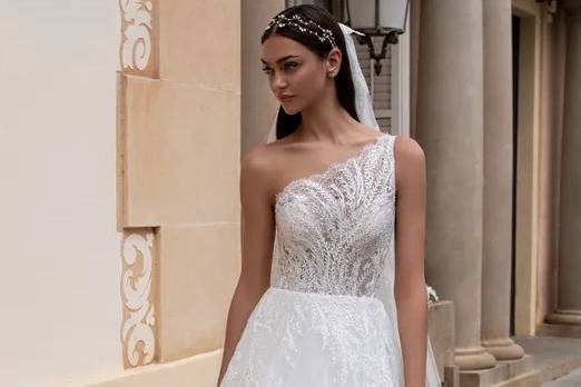 Model wearing a lace one shoulder wedding dress