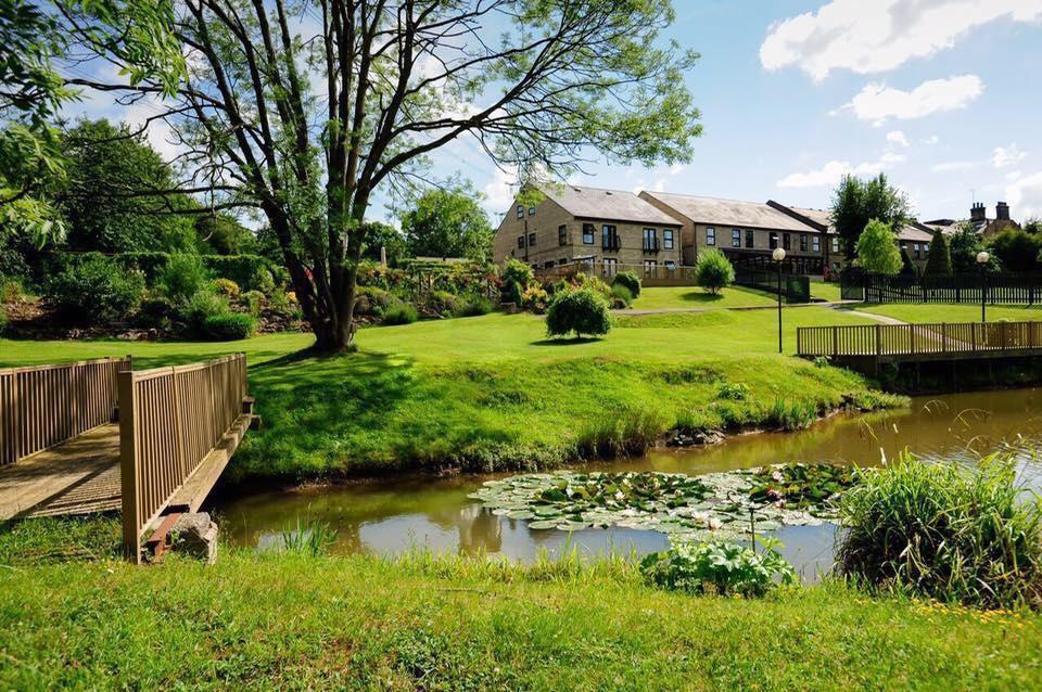 Exterior of a hotel wedding venue with a river and a bridge in the foreground