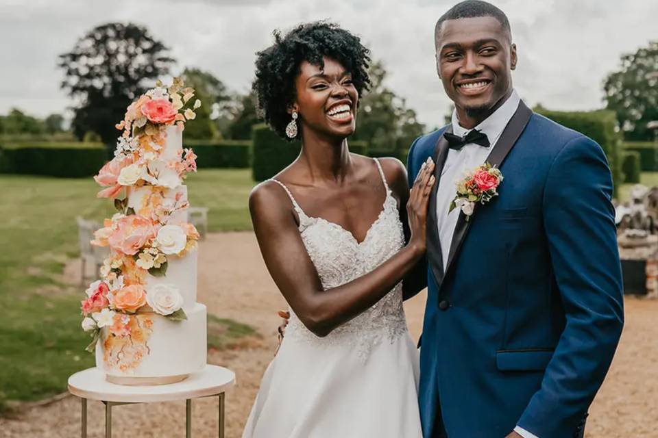 Wedding cake flavour ideas: A couple standing next to their wedding cake