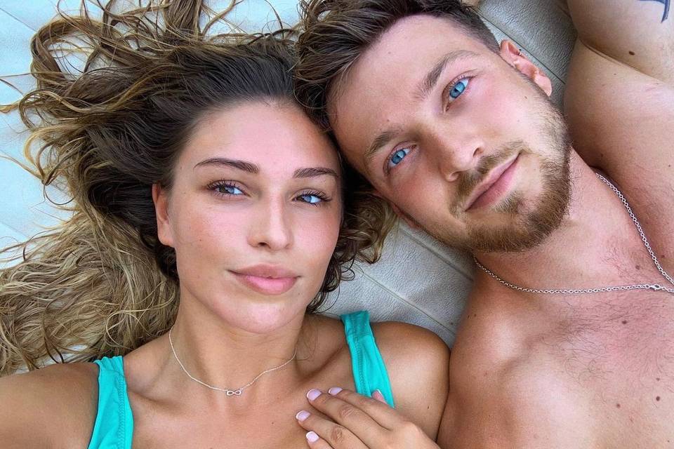 Zara McDermott taking a selfie wearinga  turquoise bikini lying down next to boyfriend Sam Thompson