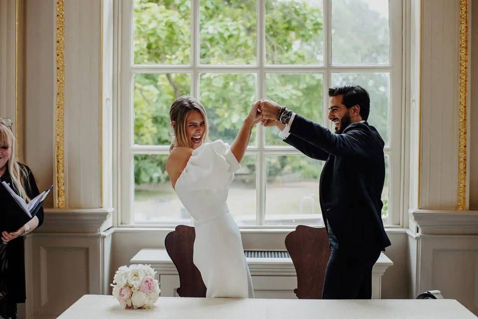 bride and groom laughing holding hands 