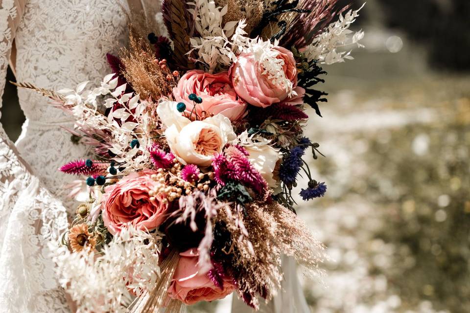 Dried hydrangea flowers in vase on background of woman arranging