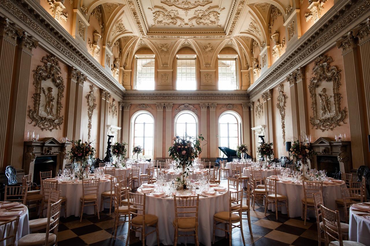 Interior of a baroque-style ballroom with parquet floor set up for a wedding reception.