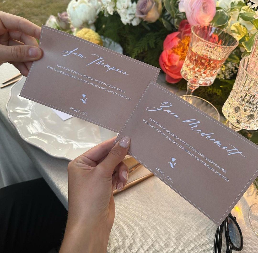 Sam Thompson and girlfriend Zara McDermott hold wedding place name cards with messages written on them