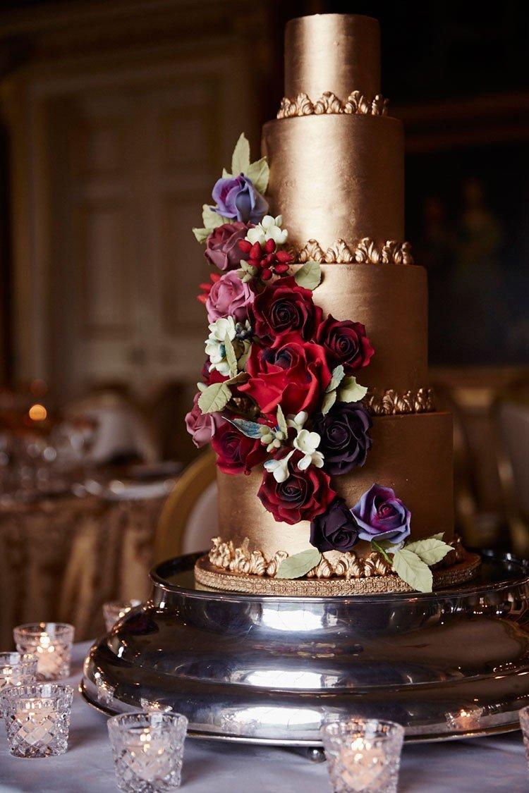 all over gold wedding cake with incredible cascading flowers