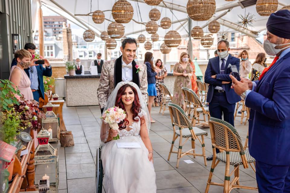 Nurani and Sam leaving the rooftop terrace of the ham yard hotel after their wedding ceremony