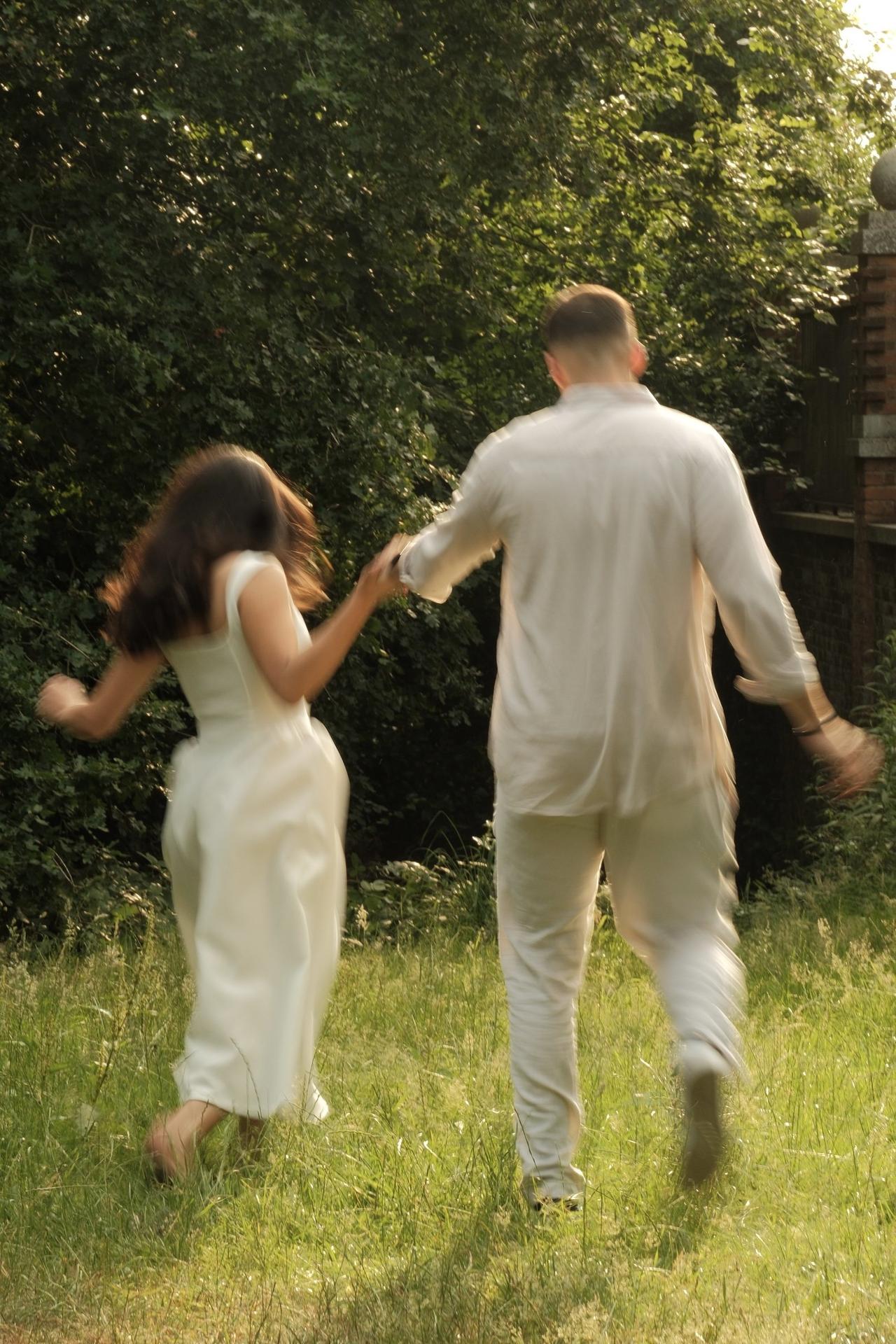 blurry shot of bride and groom walking through field