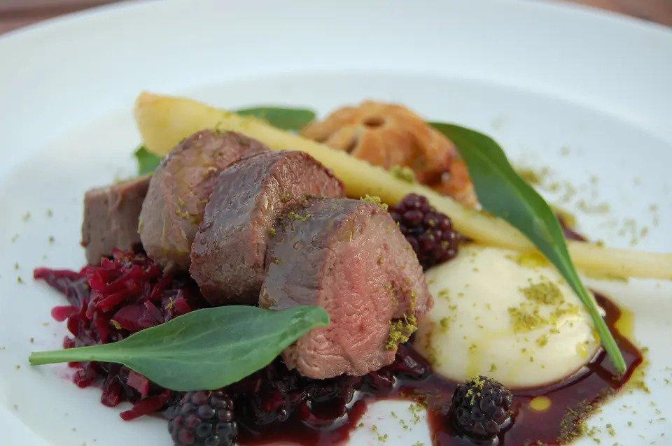 Venison served with mash, gravy and garnished with leaves and berries