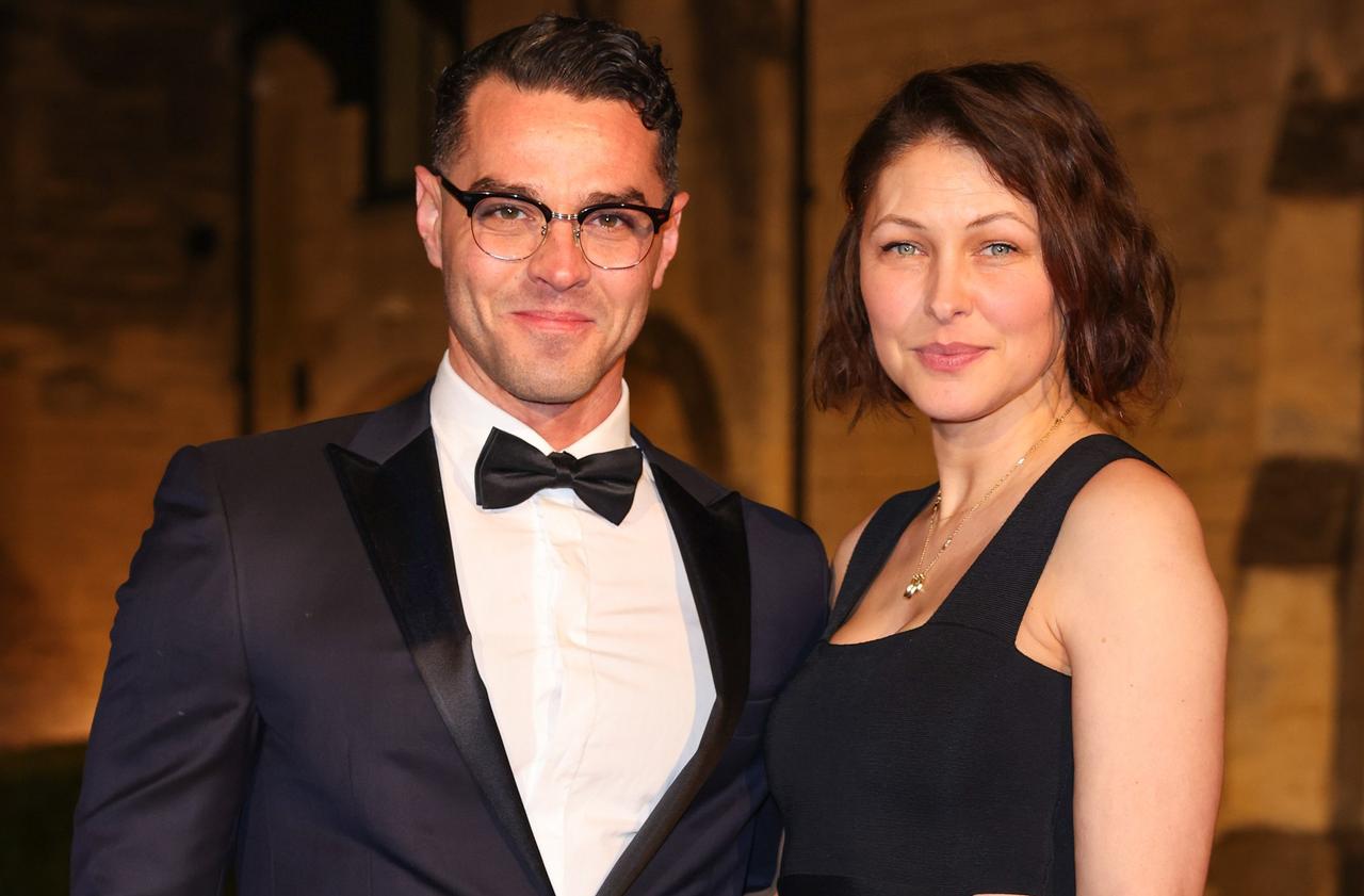 Emma Willis wears a black dress next to husband Matt Willis in a tuxedo as they pose for the press