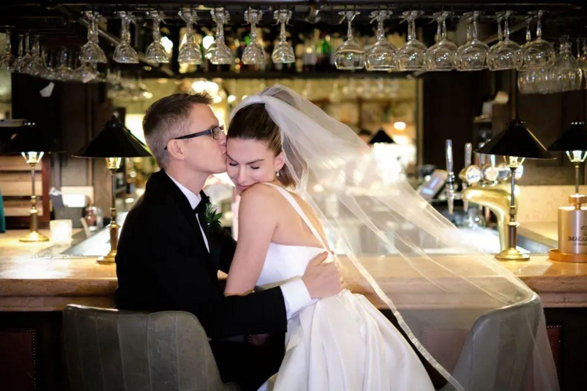 a bride and groom hugging at a bar at their wedding reception