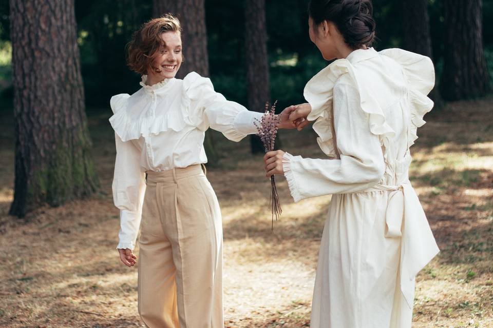 non-binary wedding outfits - couple exchanging flowers