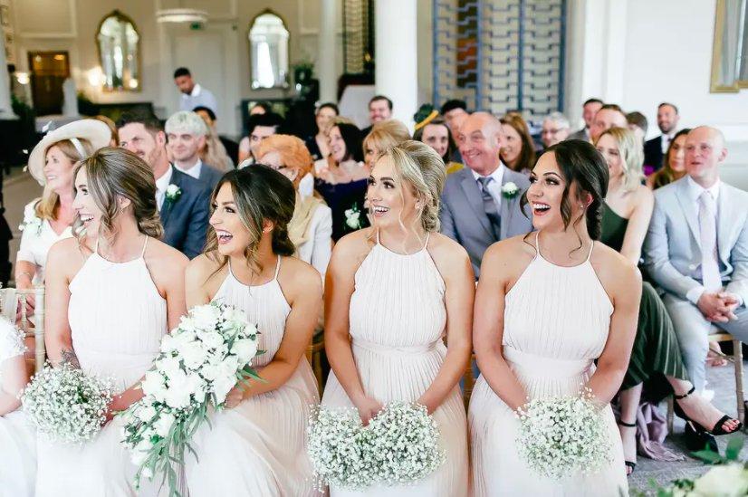 Four bridesmaids in blush pink gowns with smoky eye makeup