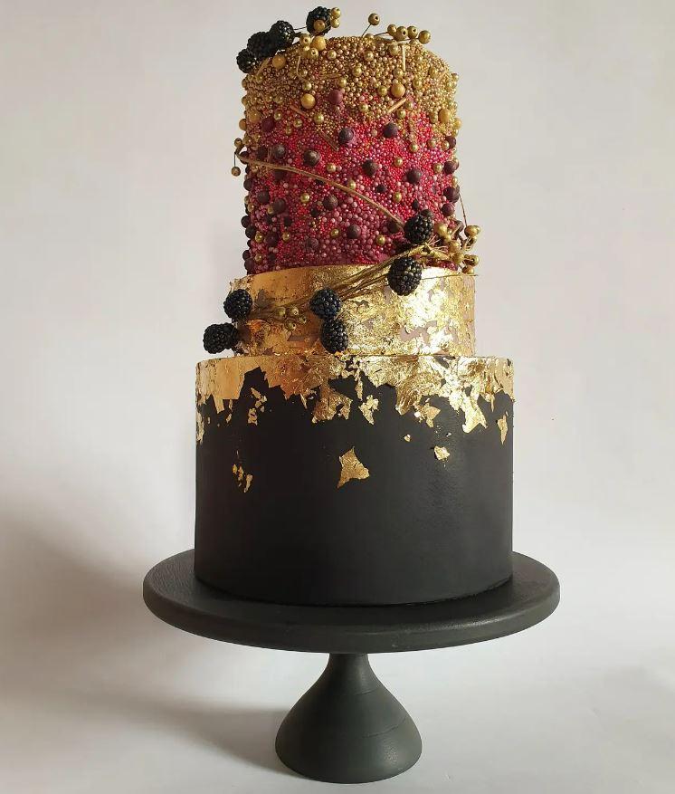 black and gold wedding cake with gold leaf