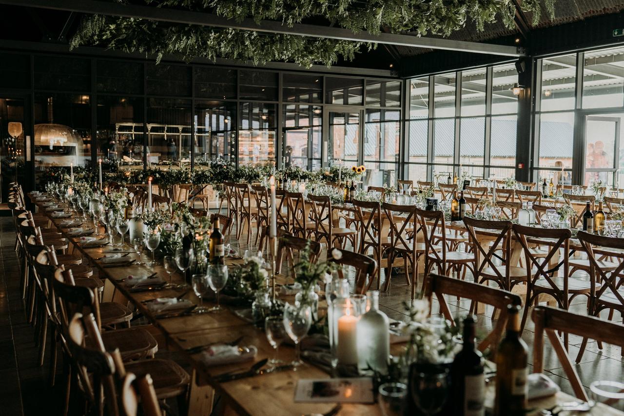 Lines of wooden tables in a barn wedding dining room