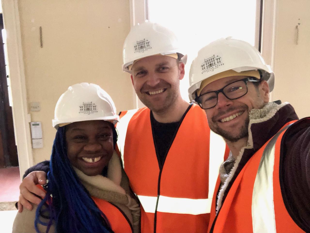 Marc Hornby with one of his couples at the building site of their new venue, Stockton House. They all wear high-vis vests and hard hats