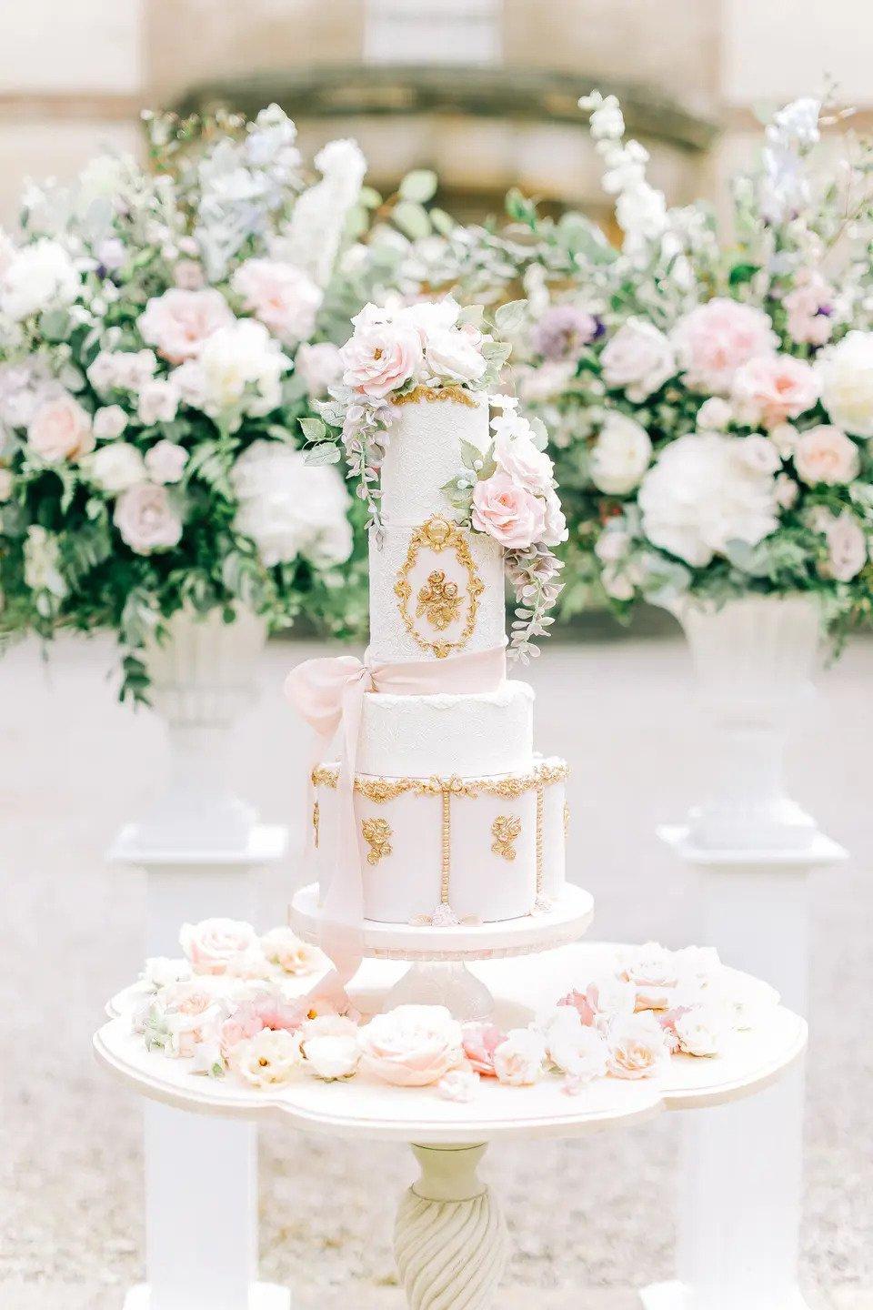 white and gold fairytale wedding cake with five tiers and gold icing