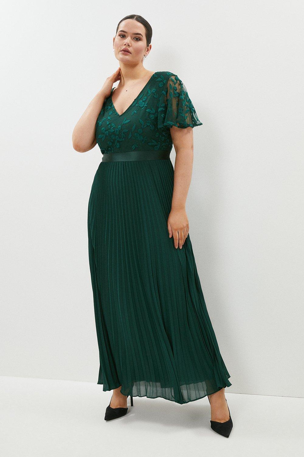 Model wearing a floral green bridesmaid dress with pleats