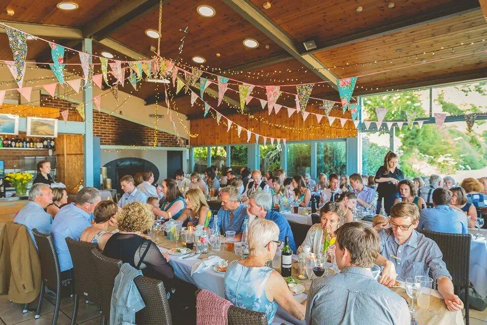 Wedding guests dining in a barn decorated in bunting