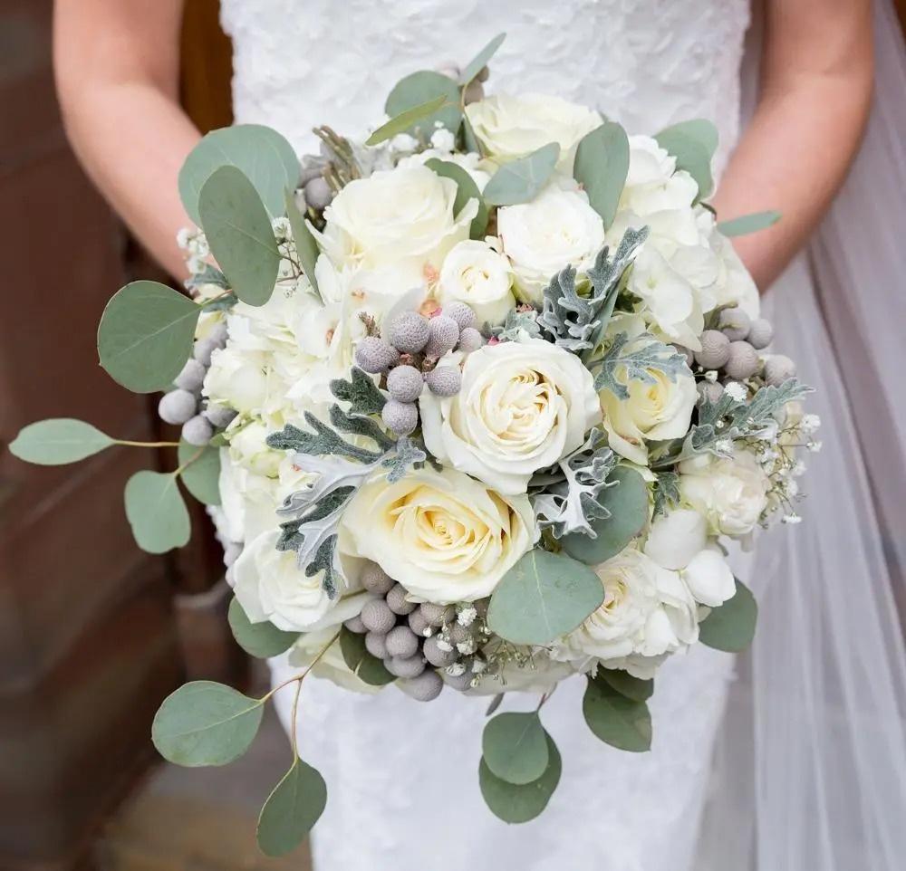 White rose wedding bouquet with winter berries and leaves