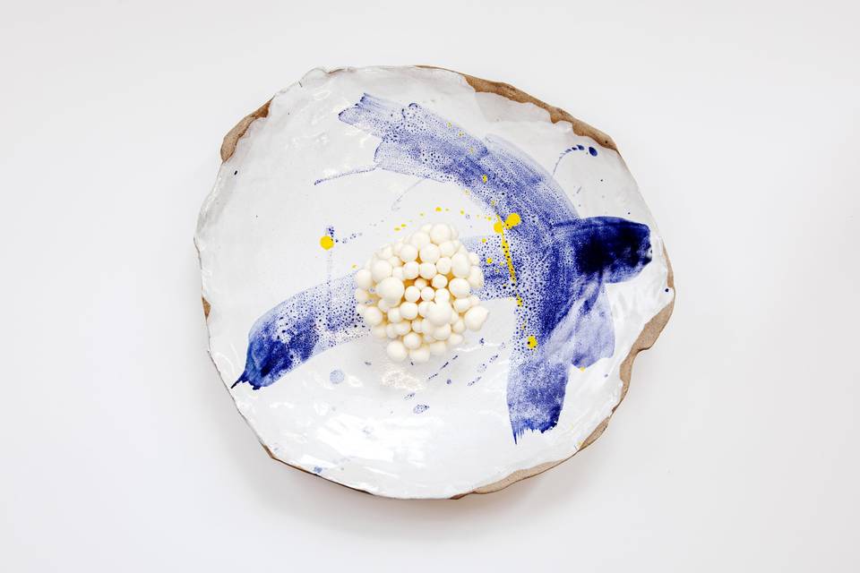 A white serving platter with blue paintwork design