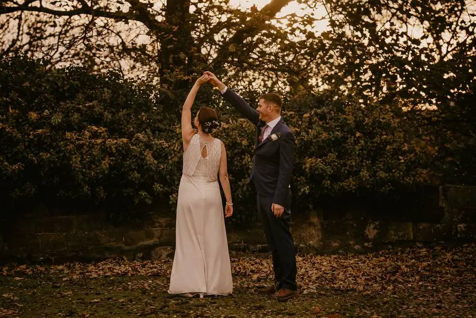 A couple dance in front of a tree