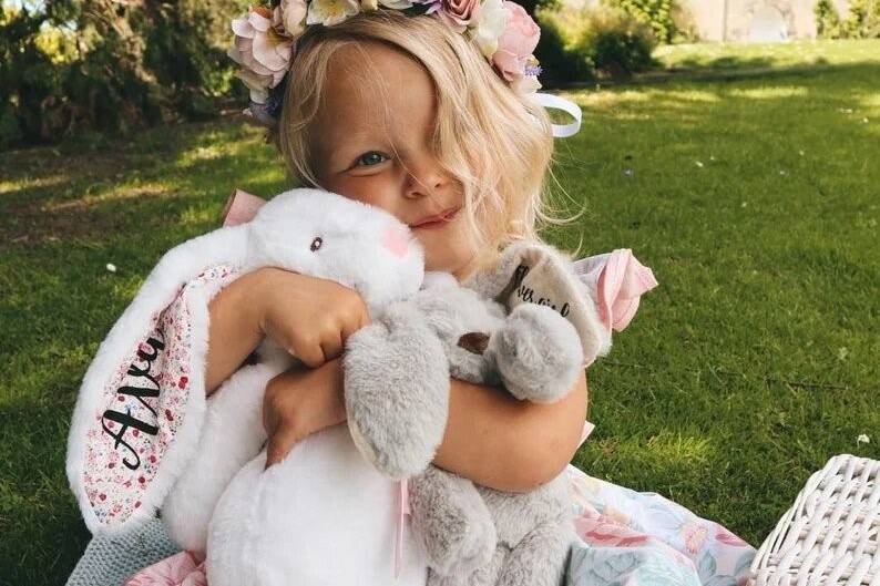 Flower girl cuddling a bunny cuddly toy