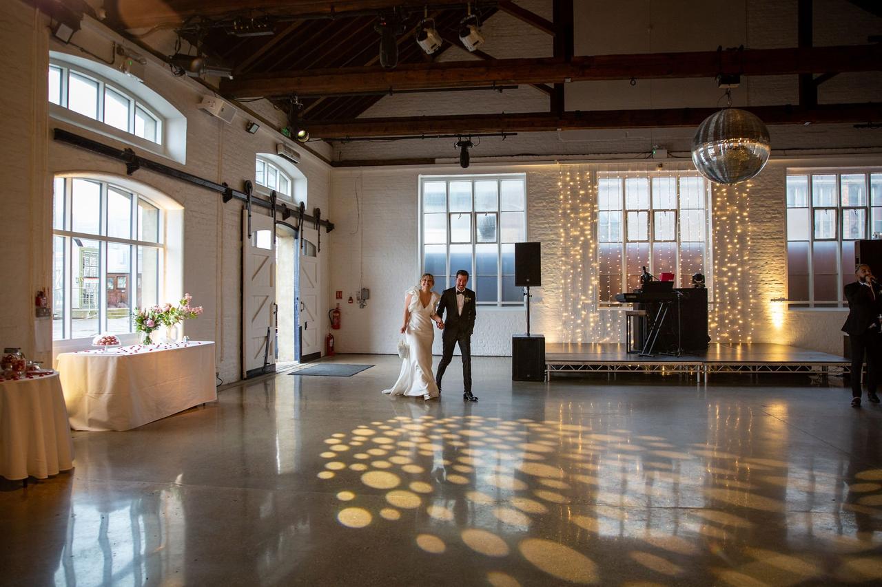 The bride and groom walk into their reception