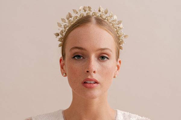 Bride wearing a headband with upright gold leaves and pearls