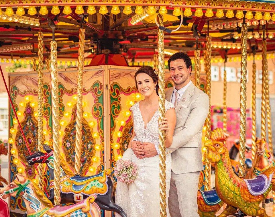 bride and groom smile at the camera while seated on hobby horses