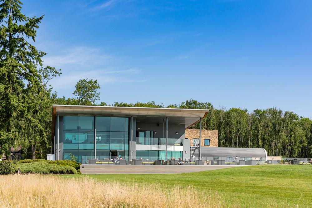 Exterior of contemporary wedding venue with glass front set in acres of countryside.