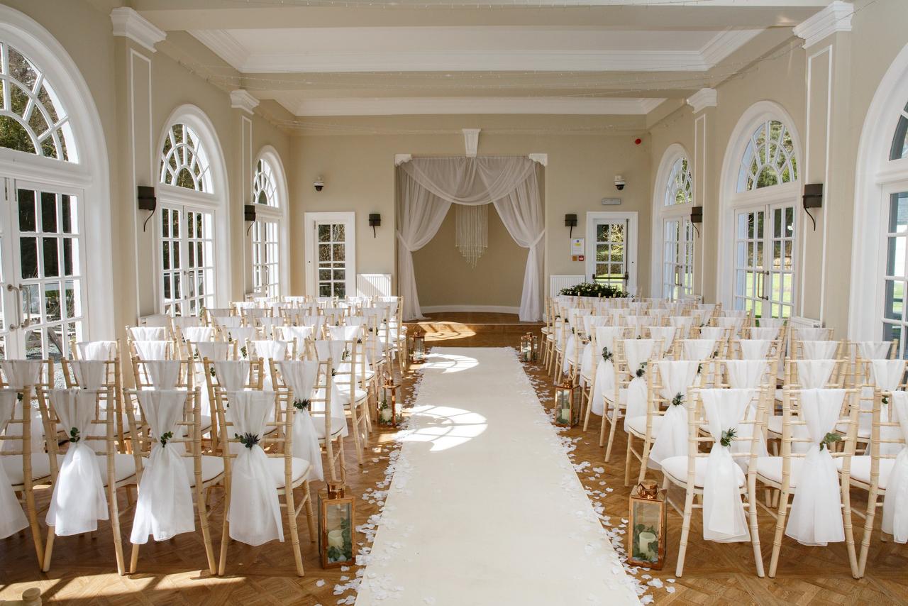 The ceremony room at Barony Castle Hotel with large bay windows and white drapes.