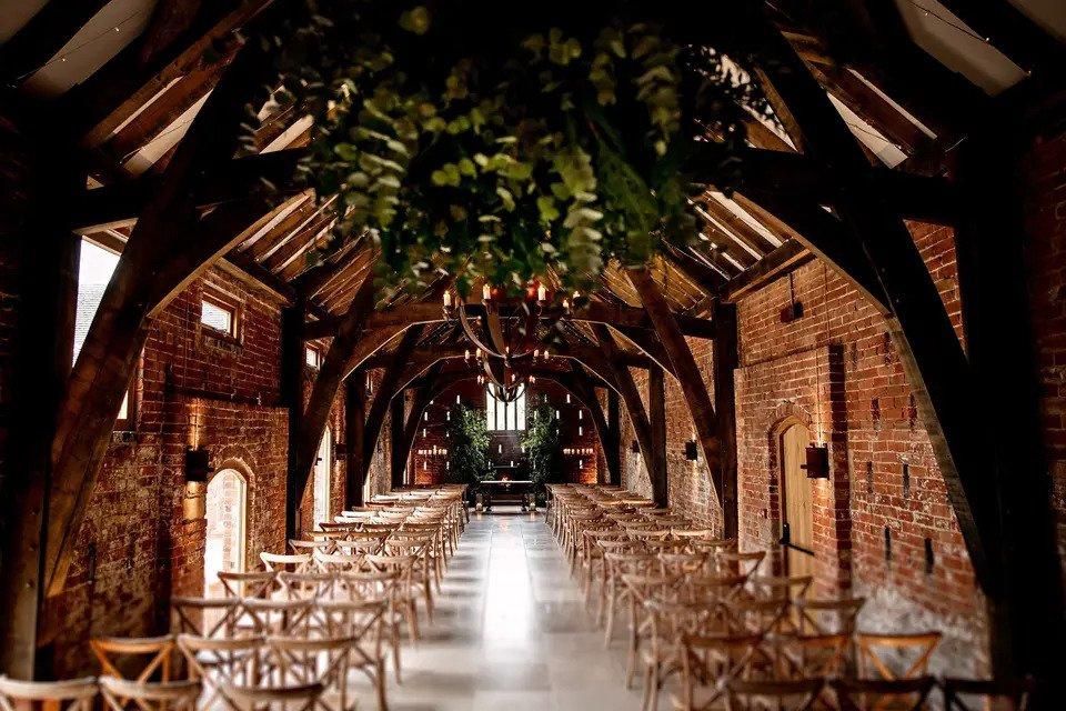 Rustic venue with wooden beams, wooden chairs and exposed brick