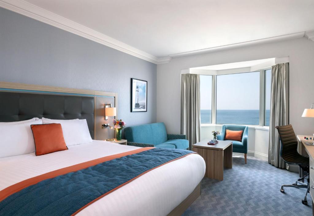 a smart bedroom with sea views and a desk in brighton hotel 