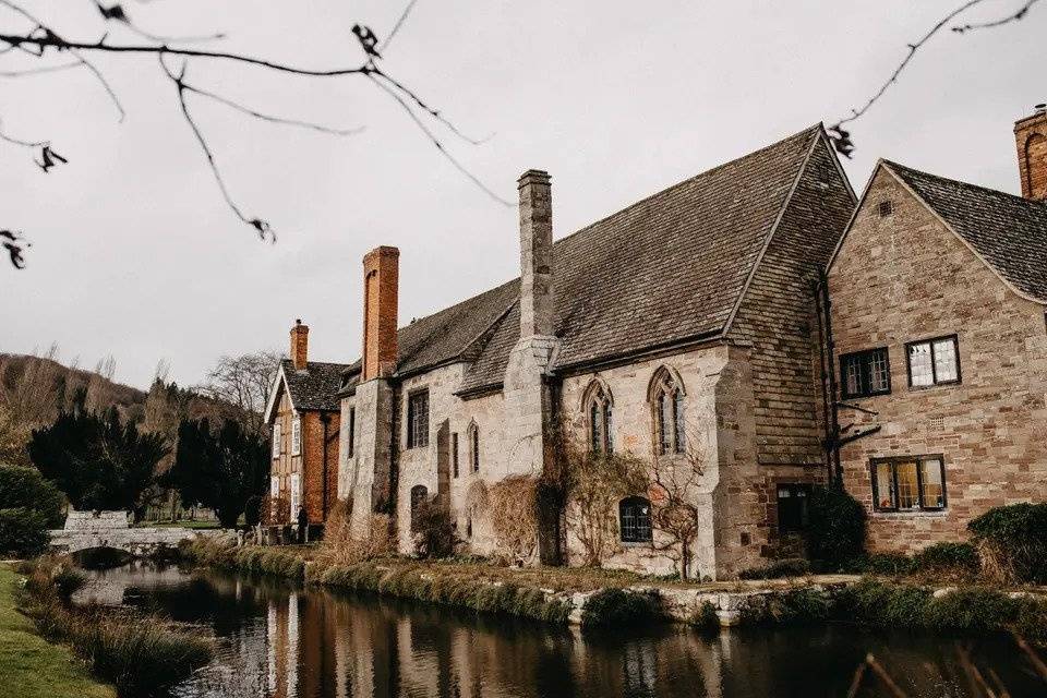 The UK's most popular wedding venue Brinsop Court pictured from across the water showing the brick exterior of the period building, complete with tall chimney stacks against a wintry sky