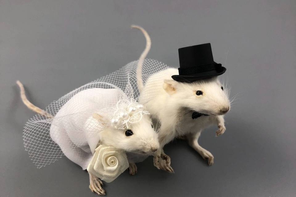 A mouse bride and groom cake topper complete with a veil, bouquet, top hat and bow tie