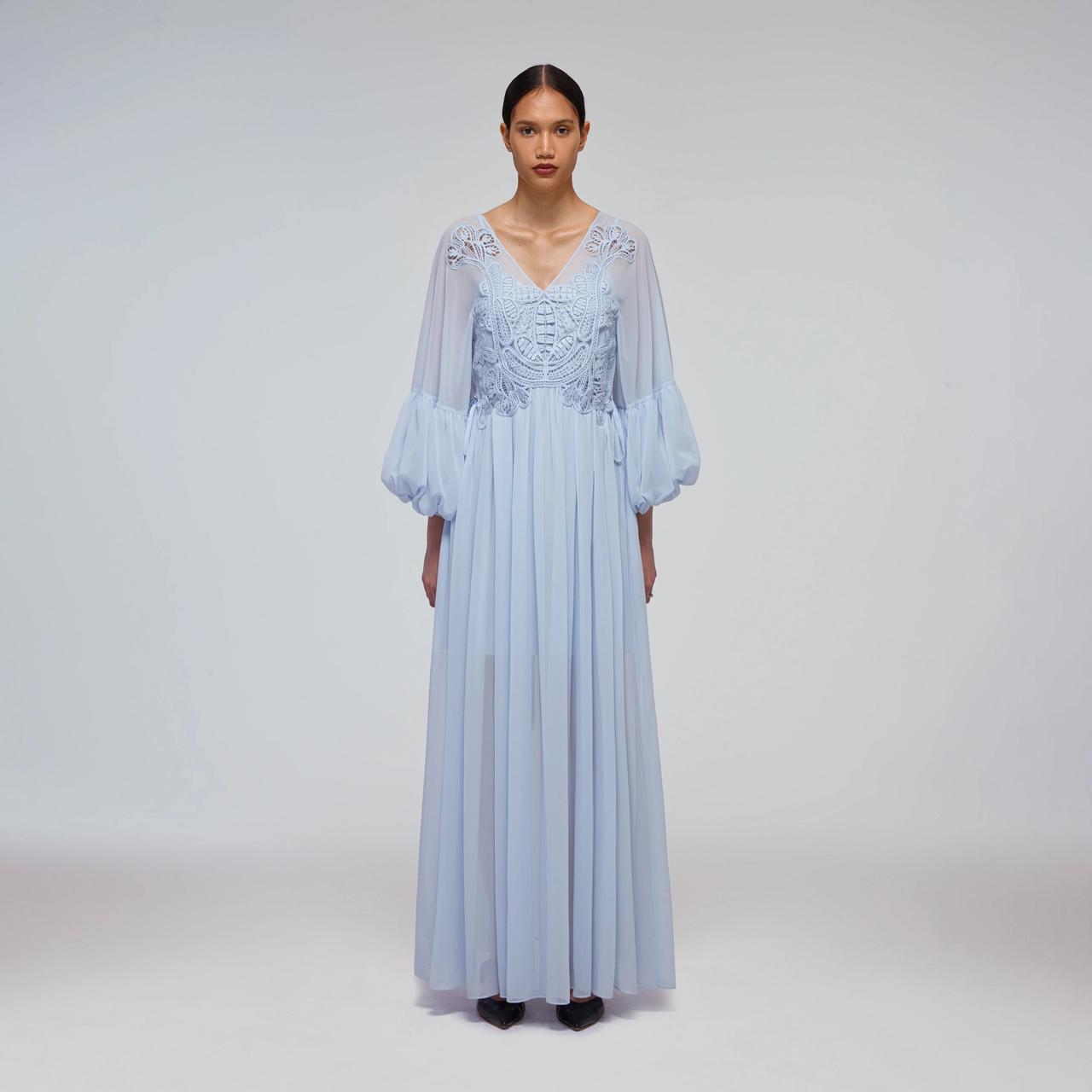 Model wearing a boho long sleeved blue wedding dress