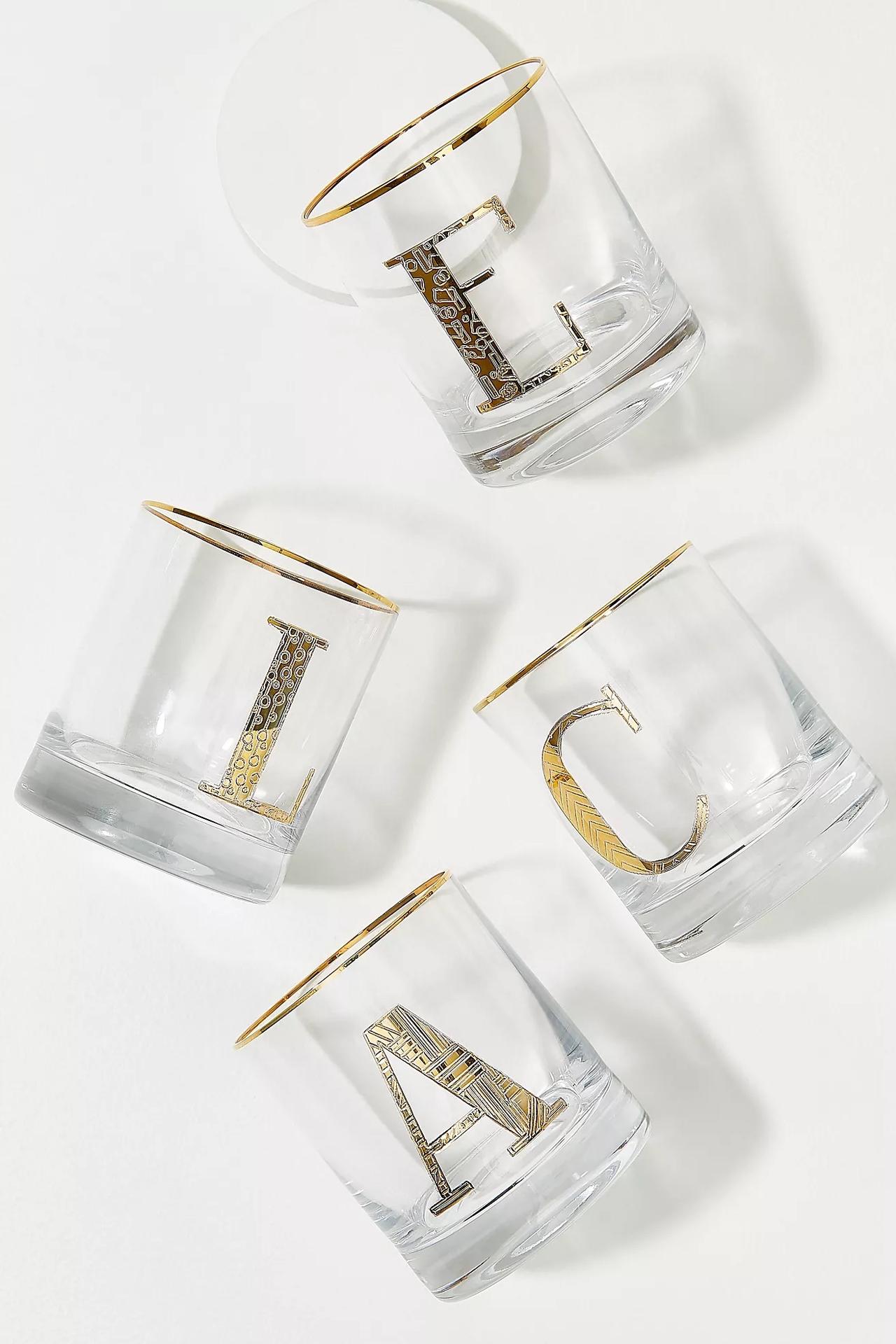 Collection of clear tumblers with different letters etched on in gold