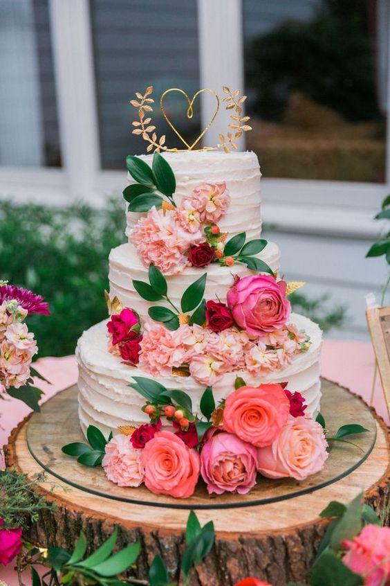 Three tiered textured buttercream rustic wedding cake with pink and red roses