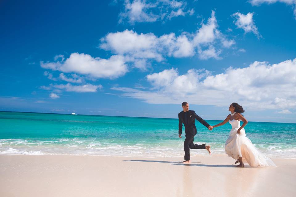 Bride and groom running on a tropical beach