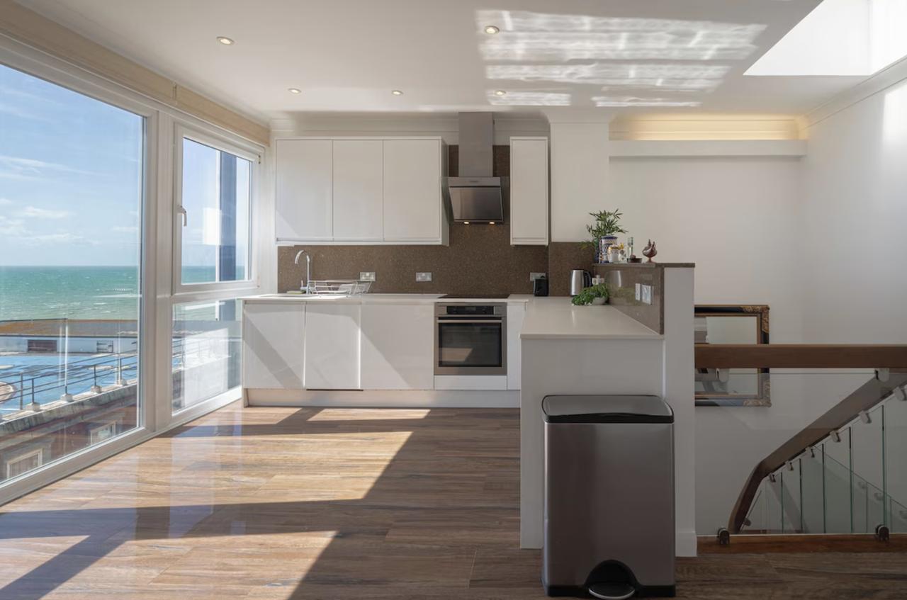Glass modern penthouse in Brighton overlooking the beach, with a modern kitchen and clean interiors