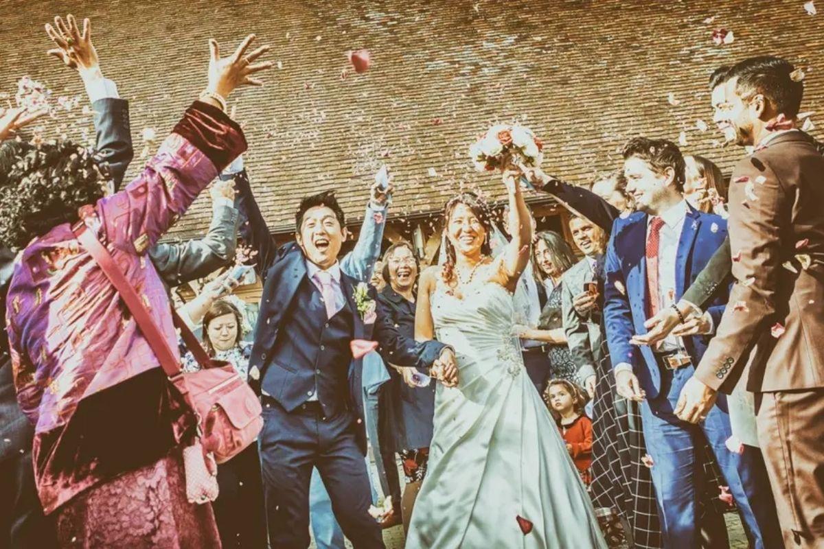 a bride and groom with their arms in the air celebrating with their guests after the wedding