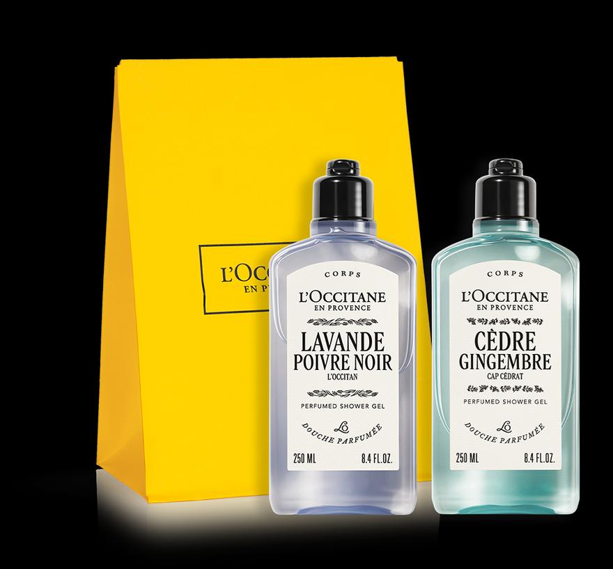 A pair of shower gel bottles from L'Occitane against yellow L'Occitane packaging.