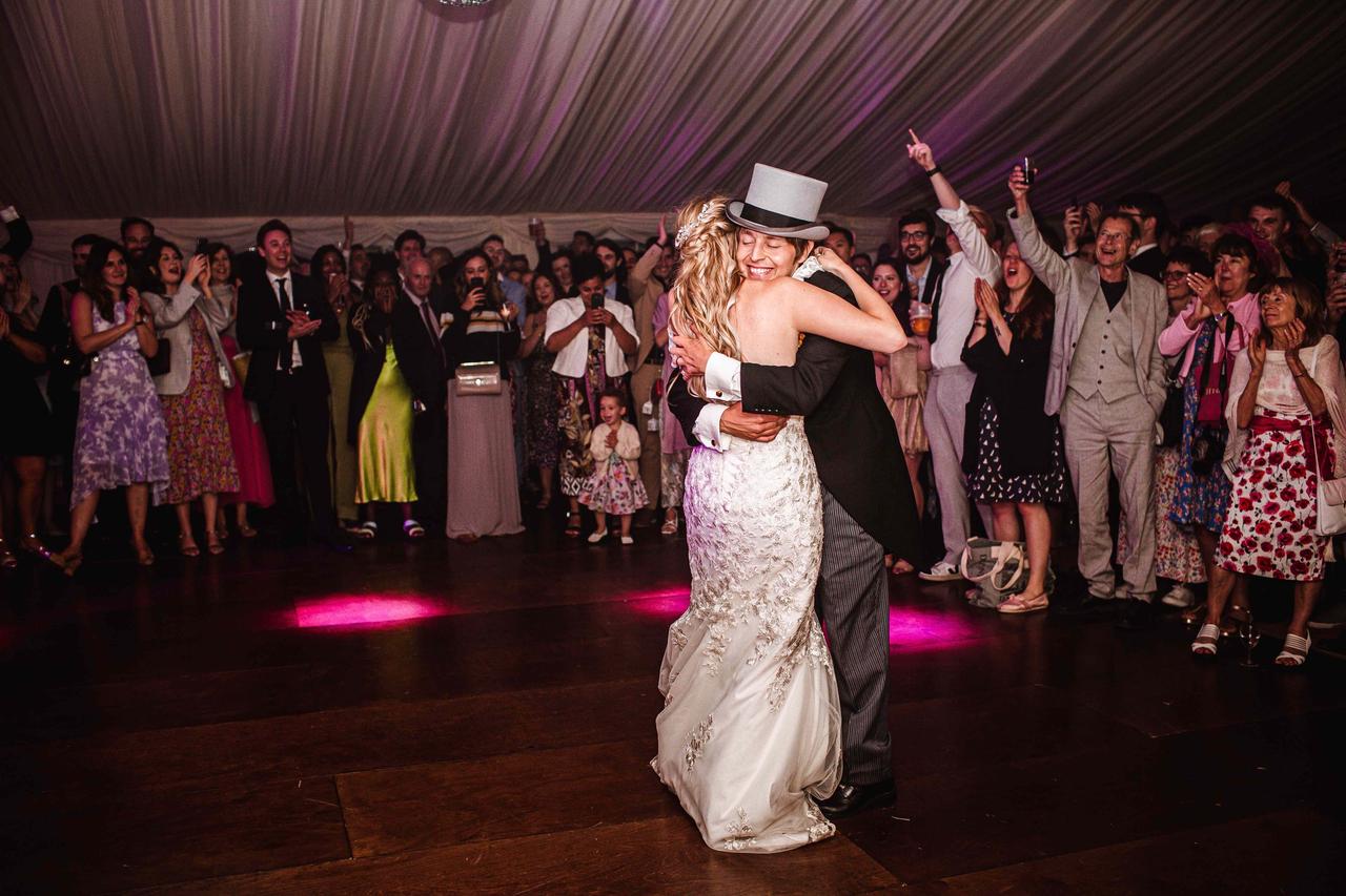 The bride and groom embrace on the dancefloor