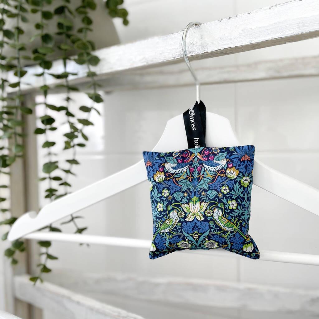  a lavender bag made of liberty print fabric on a white coathanger in a white room 