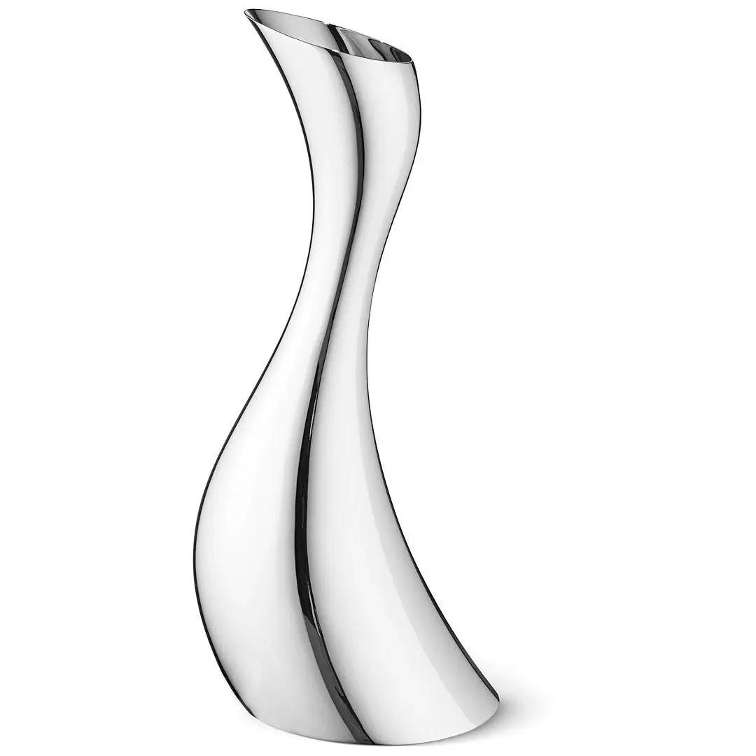 A curved shaped stainless steel pitcher on a plain white background.