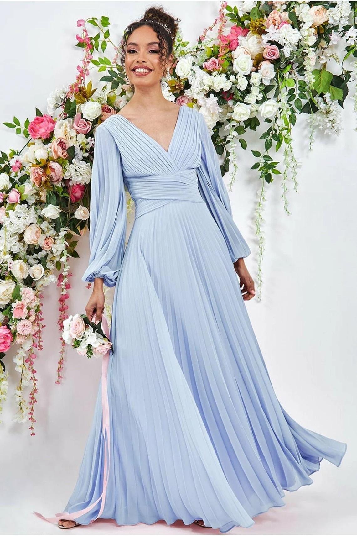 Model wearing a pleated long sleeve blue wedding dress