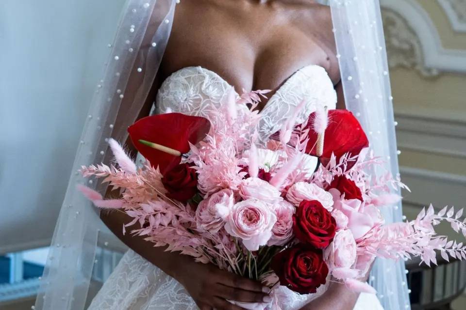 a bride with a gorgeous dobby mesh veil holding a bright bouquet of pink and red flowers